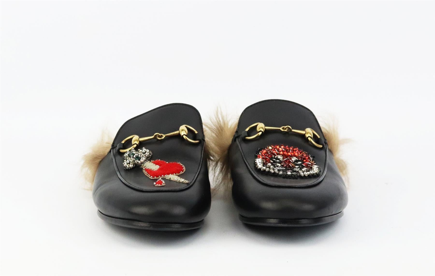 These ‘Princetown’ slippers by Gucci have been made in Italy from smooth black leather, lined in shearling-fur and topped with crystal embellished tiger motif and appliquéd dagger and heart motif. Sole measures approximately 10 mm/ 0.5 inches. Black