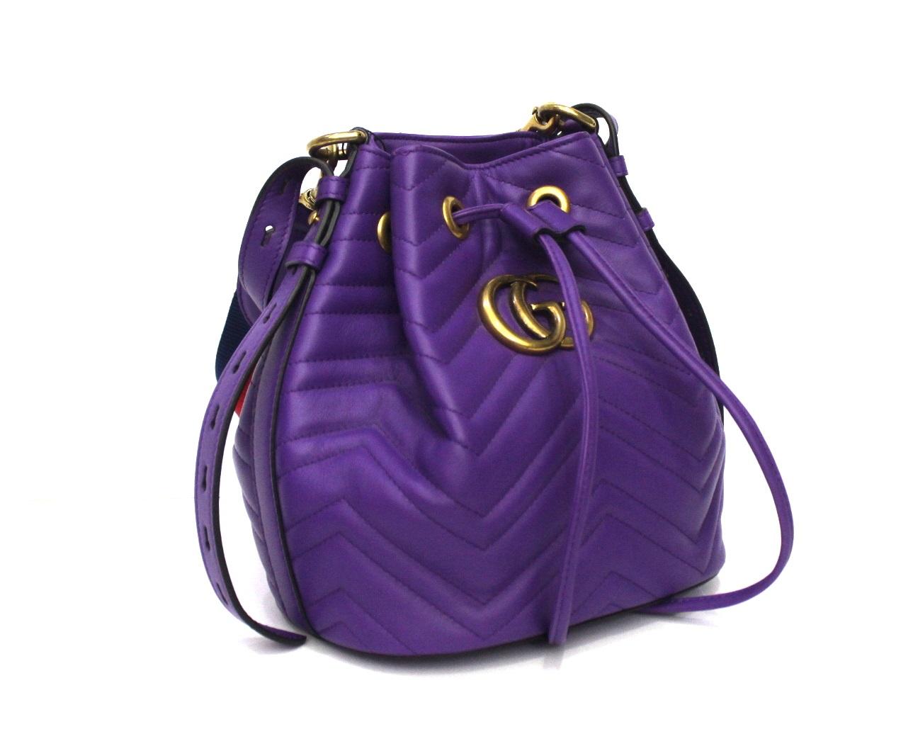 super bucket bag by Gucci Marmont line. Made of purple leather with golden hardware and shoulder strap in web band.
Closure with leather laces, internally very large. It is in mint condition, with its original dustbag.