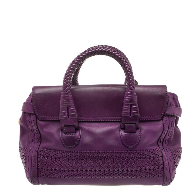 From the house of Gucci, this bag is designed using purple leather and detailed with tonal stitching and weave accents. It comes with two top handles and opens to a canvas interior fitted with pockets. Carry it in the crook of your arm or in your