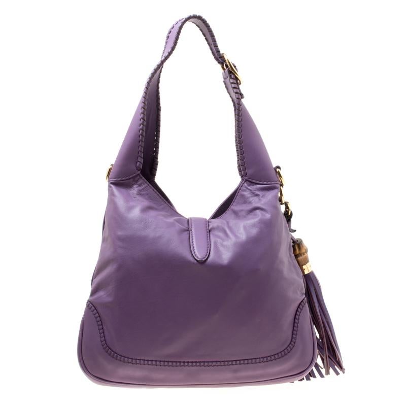 A handbag should not only be good looking but also durable, just like this pretty New Jackie bag from Gucci. Crafted from purple leather this gorgeous bag has the signature piston closure that opens up to a spacious nylon lined interior. The bag