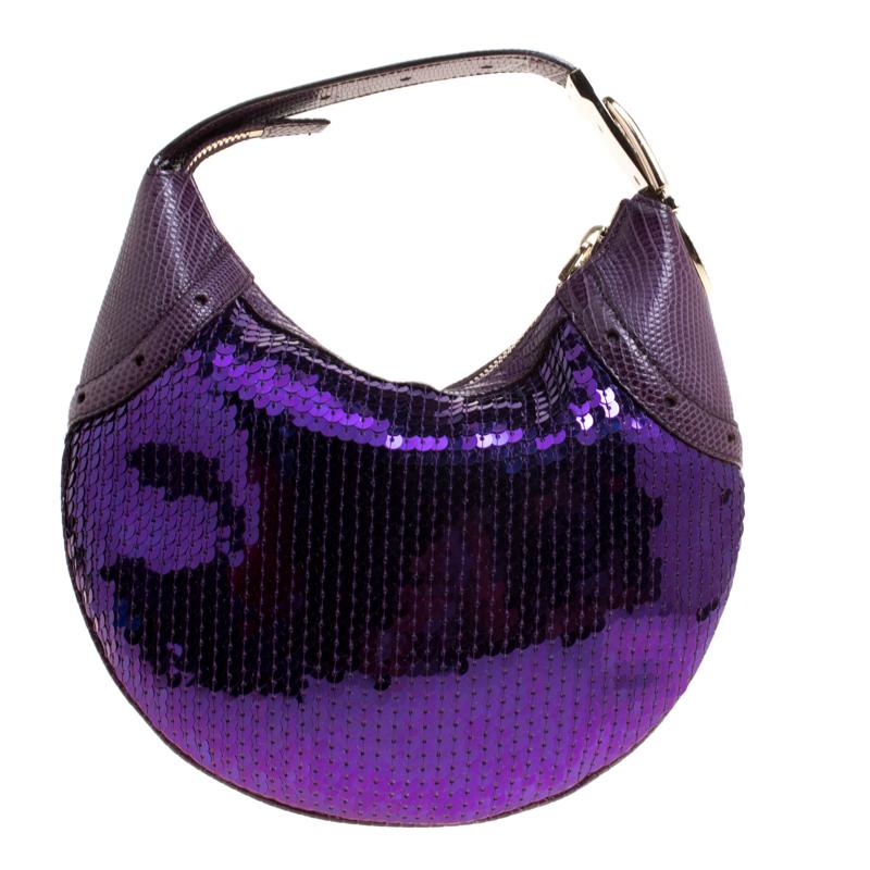 Glitzy, stylish and fashionable, this Gucci hobo will make a prized-buy. It has beautiful sequins all over, lizard trims on the sides and as the handle, and a satin interior for you to store your essentials. This purple hobo has a lovely design and