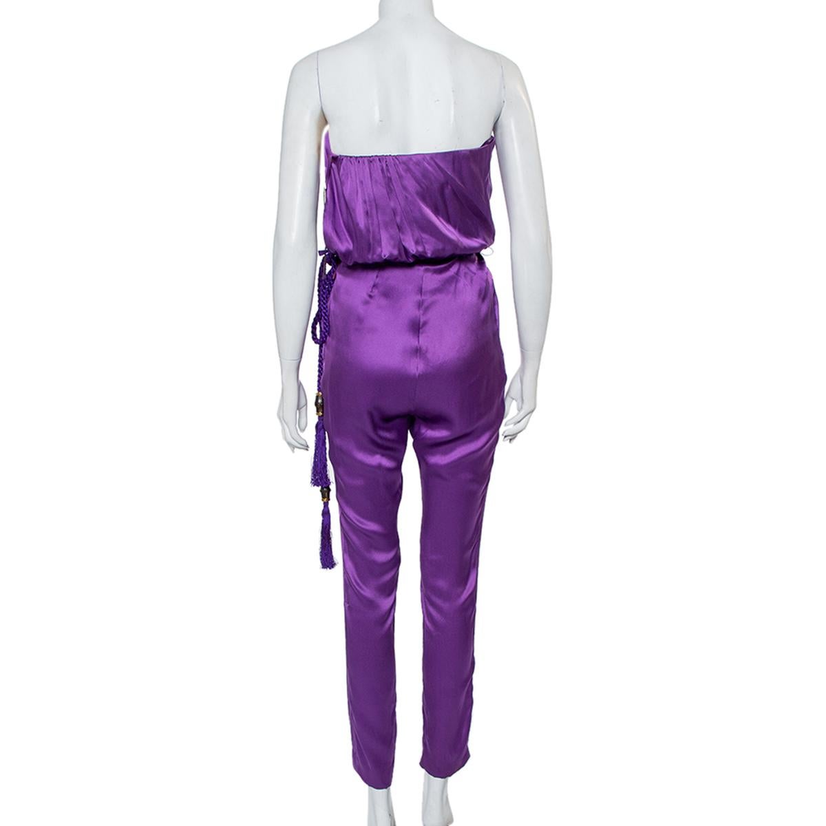 Gucci's purple silk jumpsuit with a tasseled belt is your way to statement '70s glamour. The strapless silhouette allows you to play with statement accessories. It is further made comfortable with a zip closure and pockets. This eye-catching piece