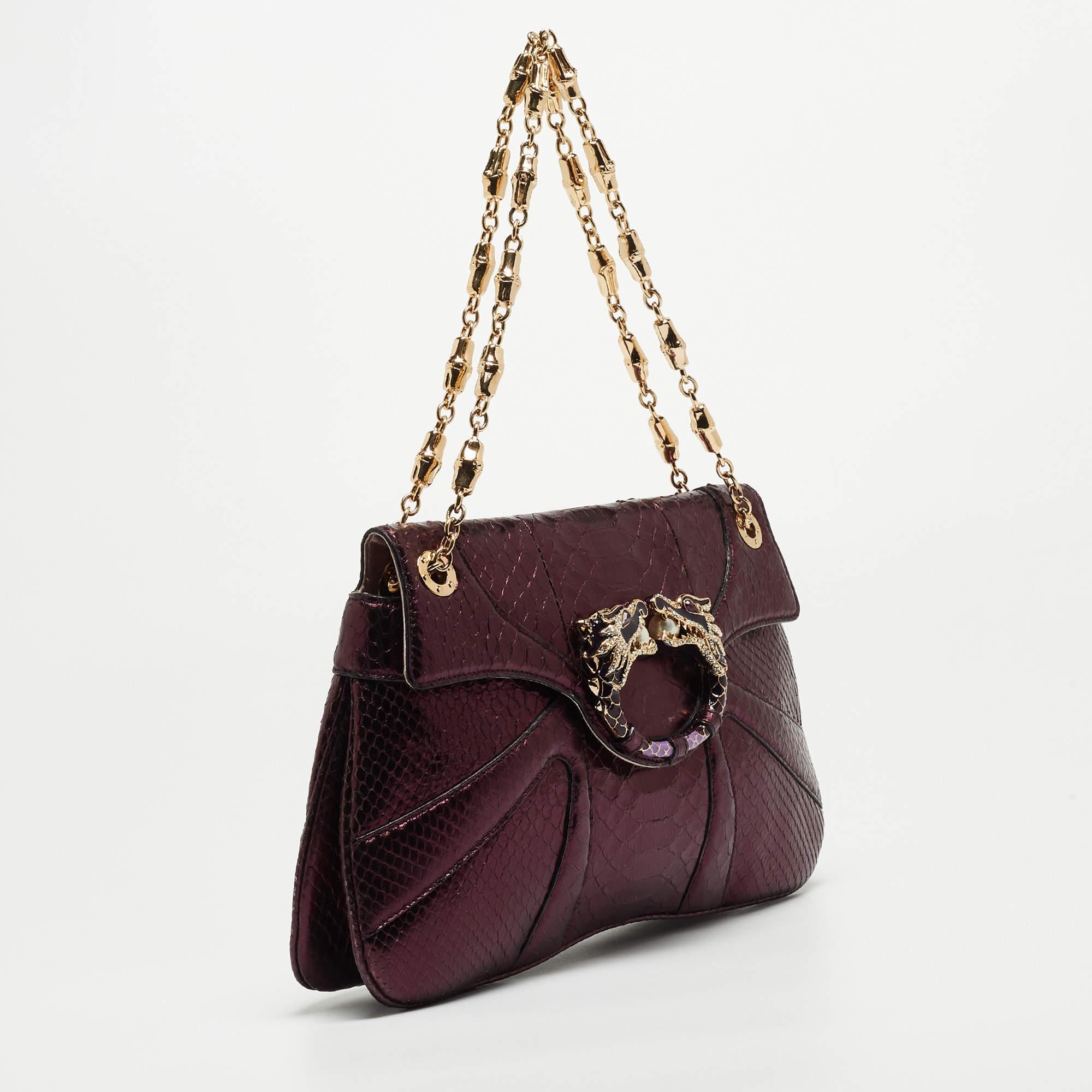 This Gucci shoulder bag beautifully shows quality craftsmanship. The interior of this gorgeous bag is lined with fabric, secured by an embellished flap, and held by a chain link.

