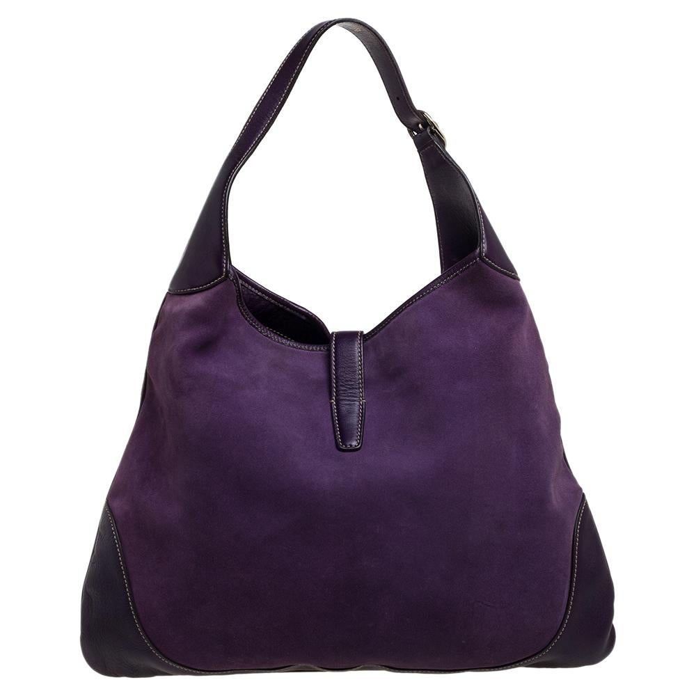 Gucci has always offered a bevy of cult-favorite bags, just like this Jackie O’ Bouvier hobo created as a homage to Jacqueline Kennedy Onassis. It is crafted from suede and leather in a purple shade and flaunts embellishments on the front. A piston