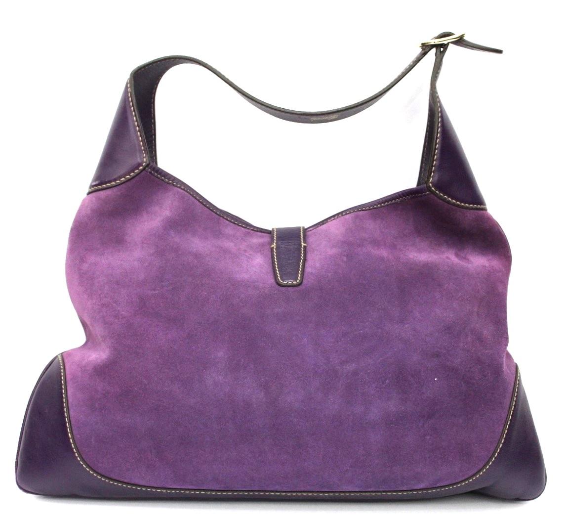 Elegant handbag by Gucci Jackie model in suede and purple leather.
Decorated on the front part by studs. Silver hardware.
Equipped with an adjustable purple leather handle.
Closing with piston.Internally large and equipped with a pocket.
Good