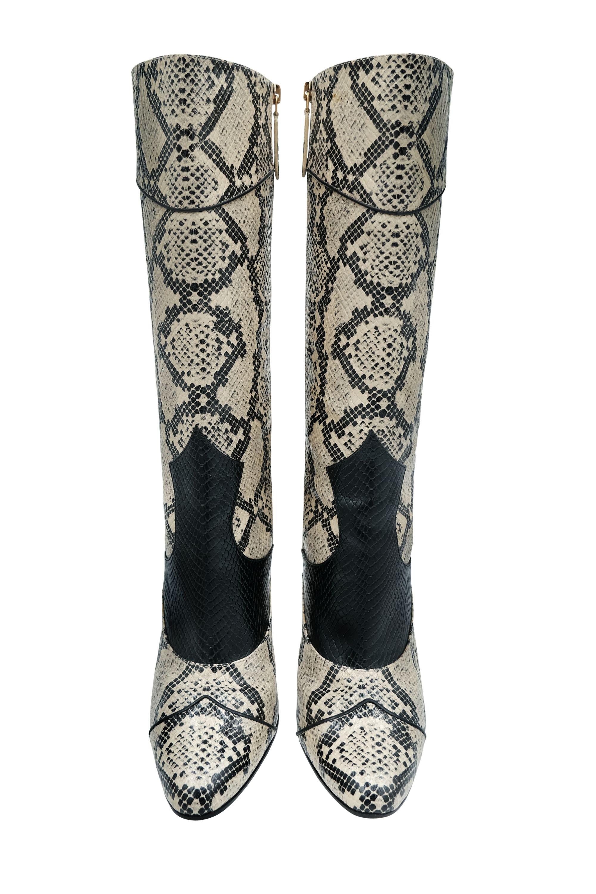 These Gucci boots are a luxurious take on Western-inspired fashion. Crafted in embossed python print leather, the boots showcase a bold snakeskin pattern in neutral tones of cream and black. The distinctive cowboy style is modernized with clean,