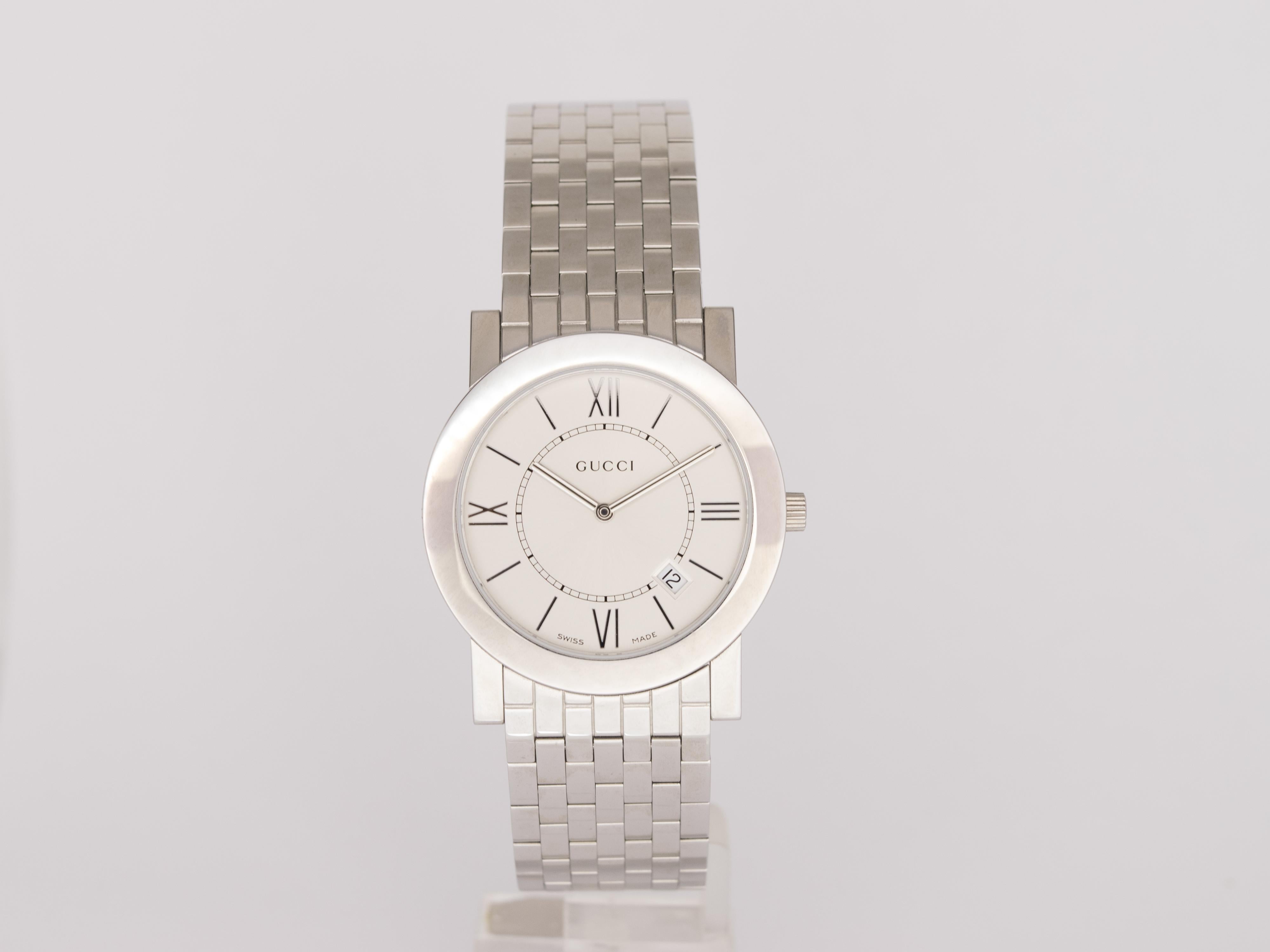 NEW Gucci Quarzuhr Swiss Made.
Die Uhr wurde nie getragen und kommt von einem italienischen Vertragshändler mit Box und internationaler Garantie.

Sie hat ein sehr großes und klares Argentee-Zifferblatt mit römischem Index und ein Datumsfenster bei