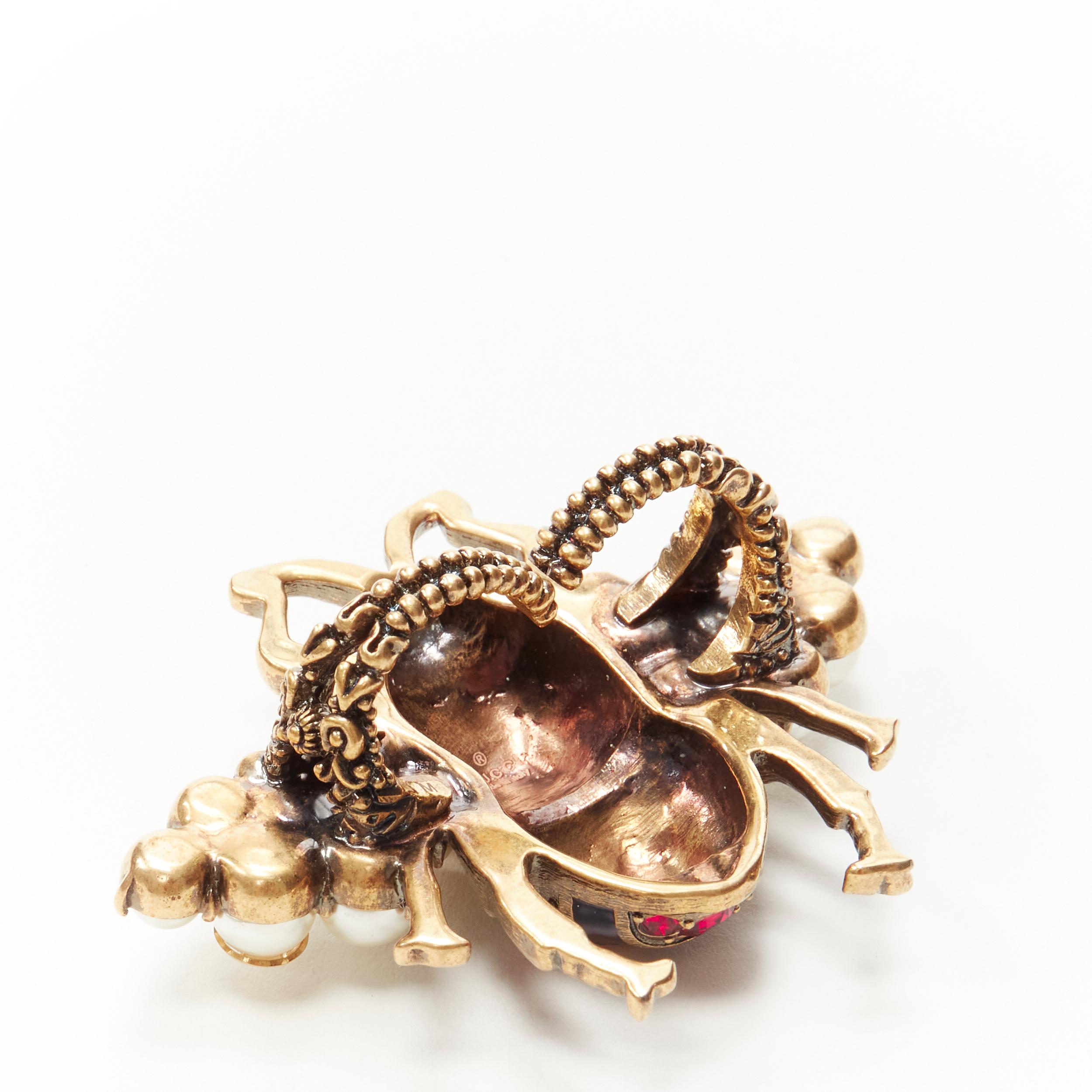GUCCI Queen Margaret Bee pea; crystal enamel double finger cocktail ring 
Reference: ANWU/A00158 
Brand: Gucci 
Designer: Alessandro Michele 
Collection: Queen Margaret Bee 
Material: Metal 
Color: Gold 
Pattern: Bee 
Extra Detail: Antique gold-tone