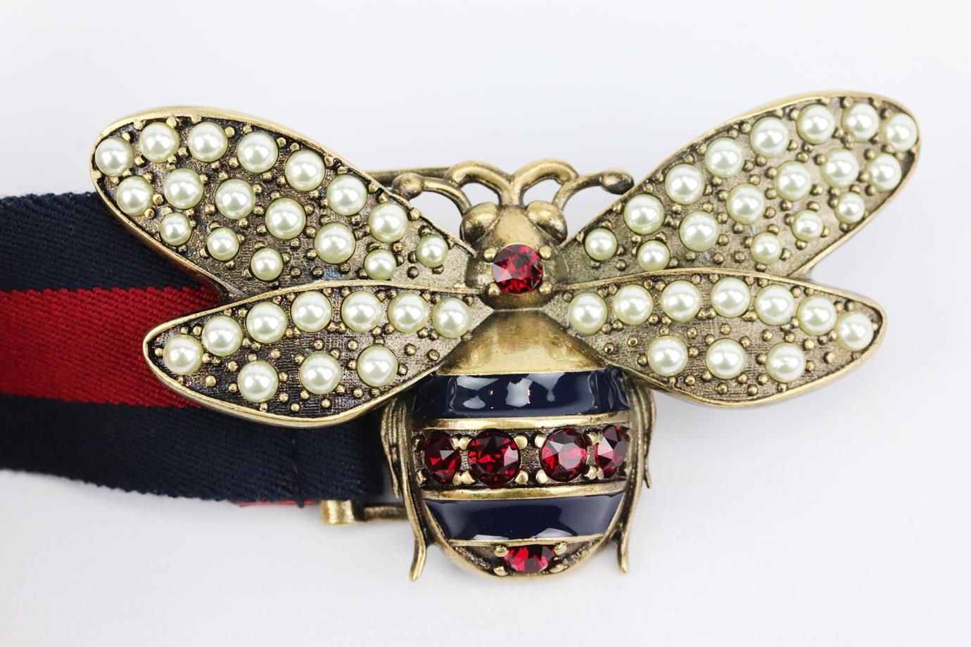 This ‘Queen Margaret’ waist belt by Gucci has been crafted by artisans in the house's Italian atelier, in keeping with tradition, made from striped elasticated band and finished with embellished gold-tone bee clasp at the front. Navy and red