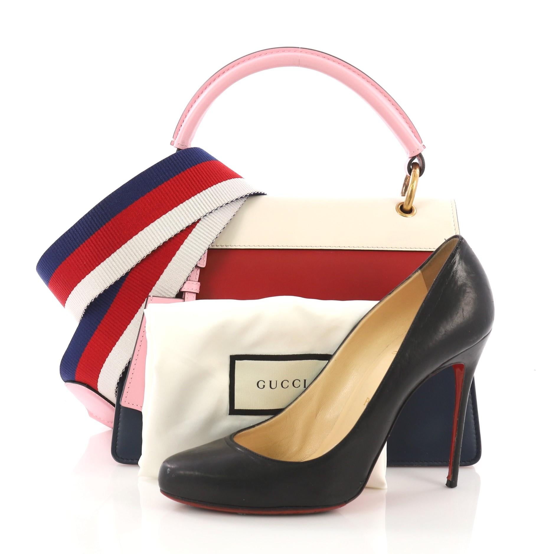 This Gucci Queen Margaret Top Handle Bag Colorblock Leather Small, crafted from red, blue and white leather, features a leather top handle, bejeweled bee on its flap, and aged gold-tone hardware. It opens to a beige microfiber interior divided into