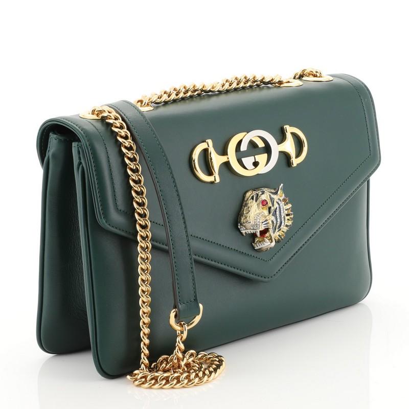 This Gucci Rajah Chain Shoulder Bag Leather Medium, crafted in green leather, features chain link shoulder strap, enameled tiger head with crystals inspired by a vintage Hattie Carnegie jewelry design, Horsebit and the Interlocking G detailing and