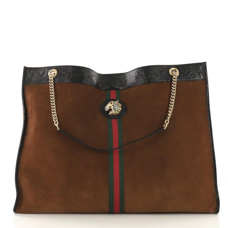 This Gucci Rajah Chain Tote Suede XL, crafted from brown suede, features chain straps with leather pads, web stripe detailing, enameled tiger head with crystals, and gold-tone hardware. Its magnetic snap closure opens to a brown leather interior.