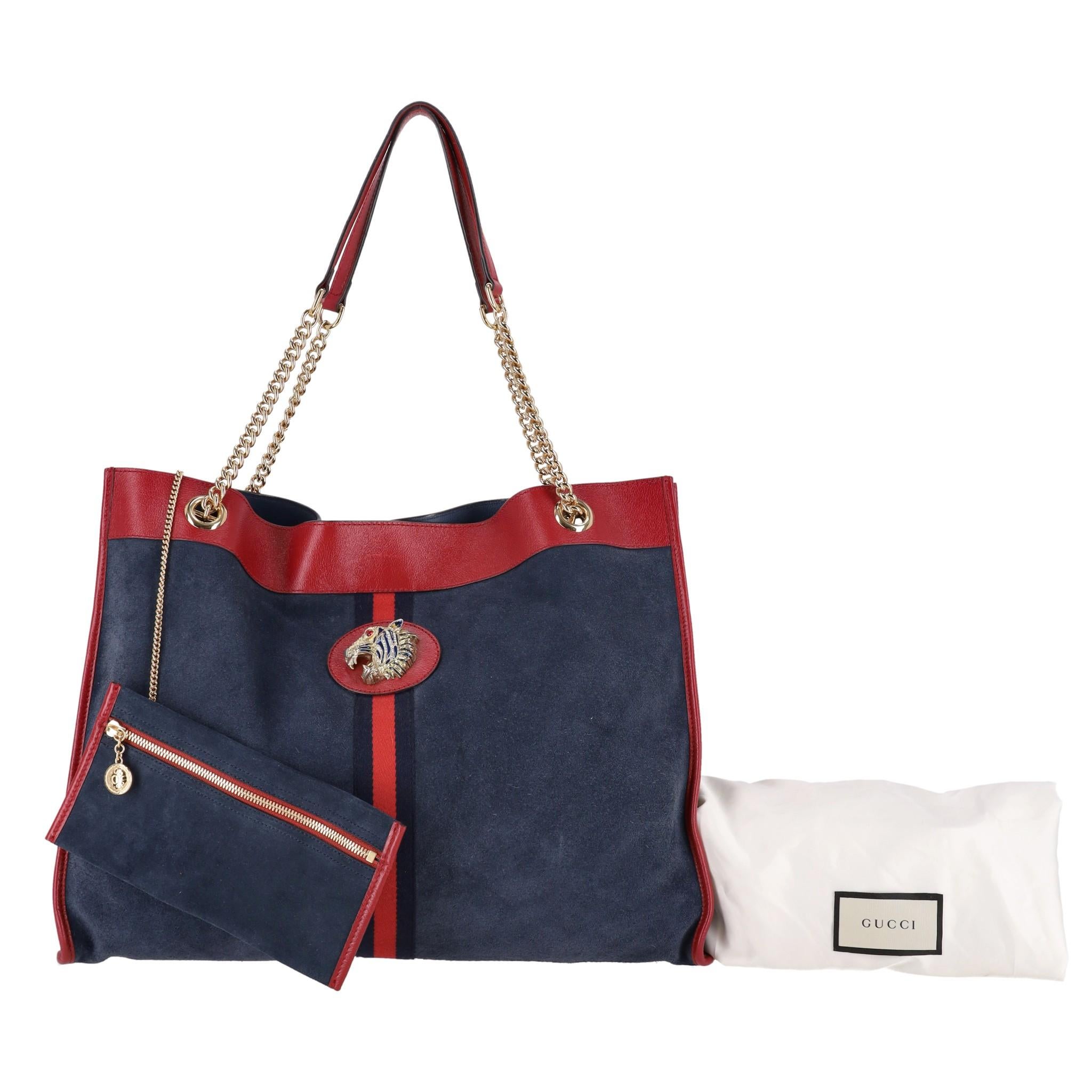 Gucci Rajah Large Suede Shopper Bag & Pouch


Navy tote bag and detachable pouch crafted from suede with red leather trims.

Detailed with the brand's signature blue and red Web stripe inlaid onto the front. 

Jewelled enamelled tiger head with