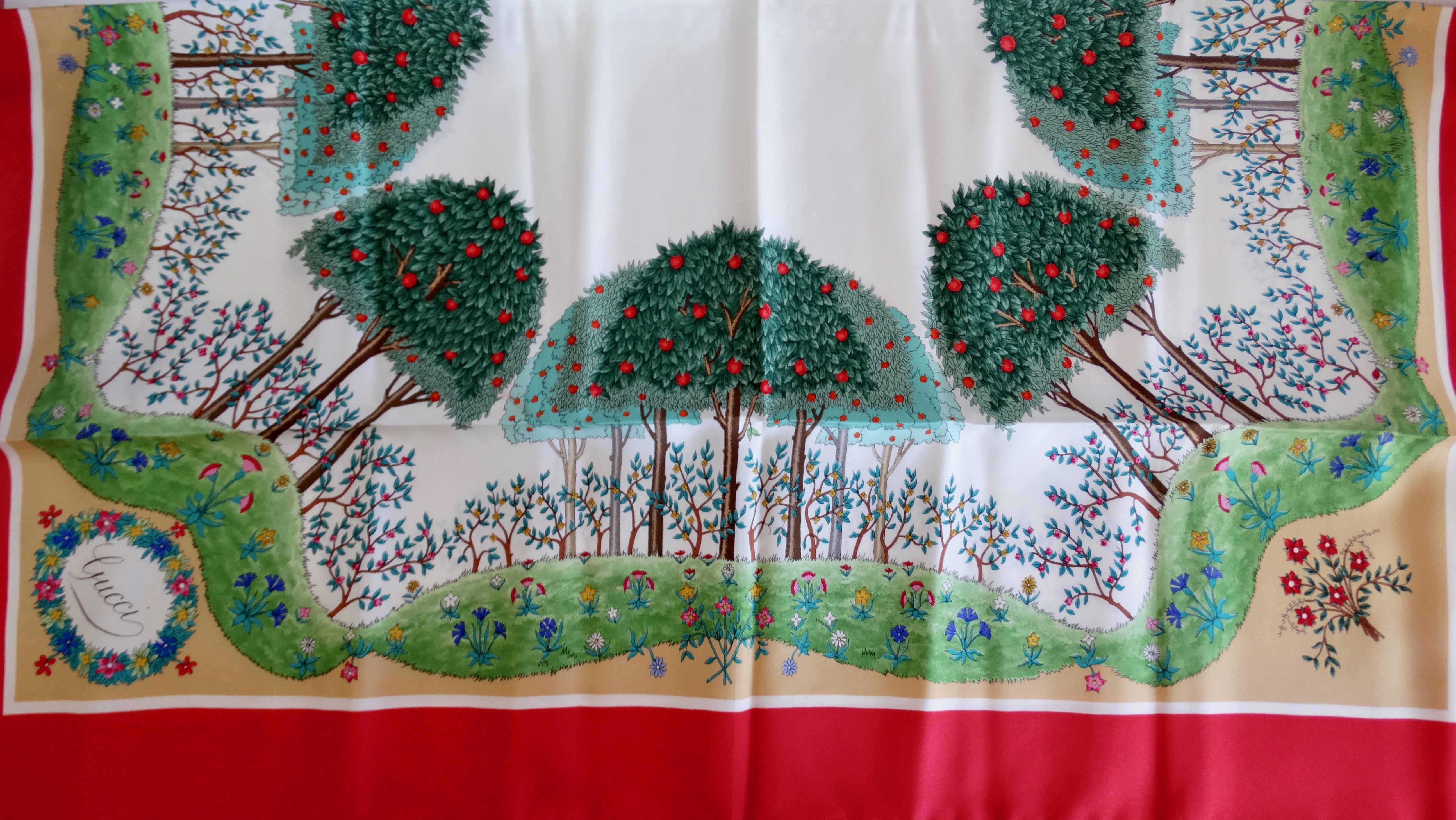 Everyone need a Gucci scarf in their wardrobe! Circa 1970s, this gorgeous and rare Gucci silk scarf features an apple orchard motif designed by Vittorio Accornero. Motif includes a vibrant apple orchard with fields of colorful flowers. An ivory