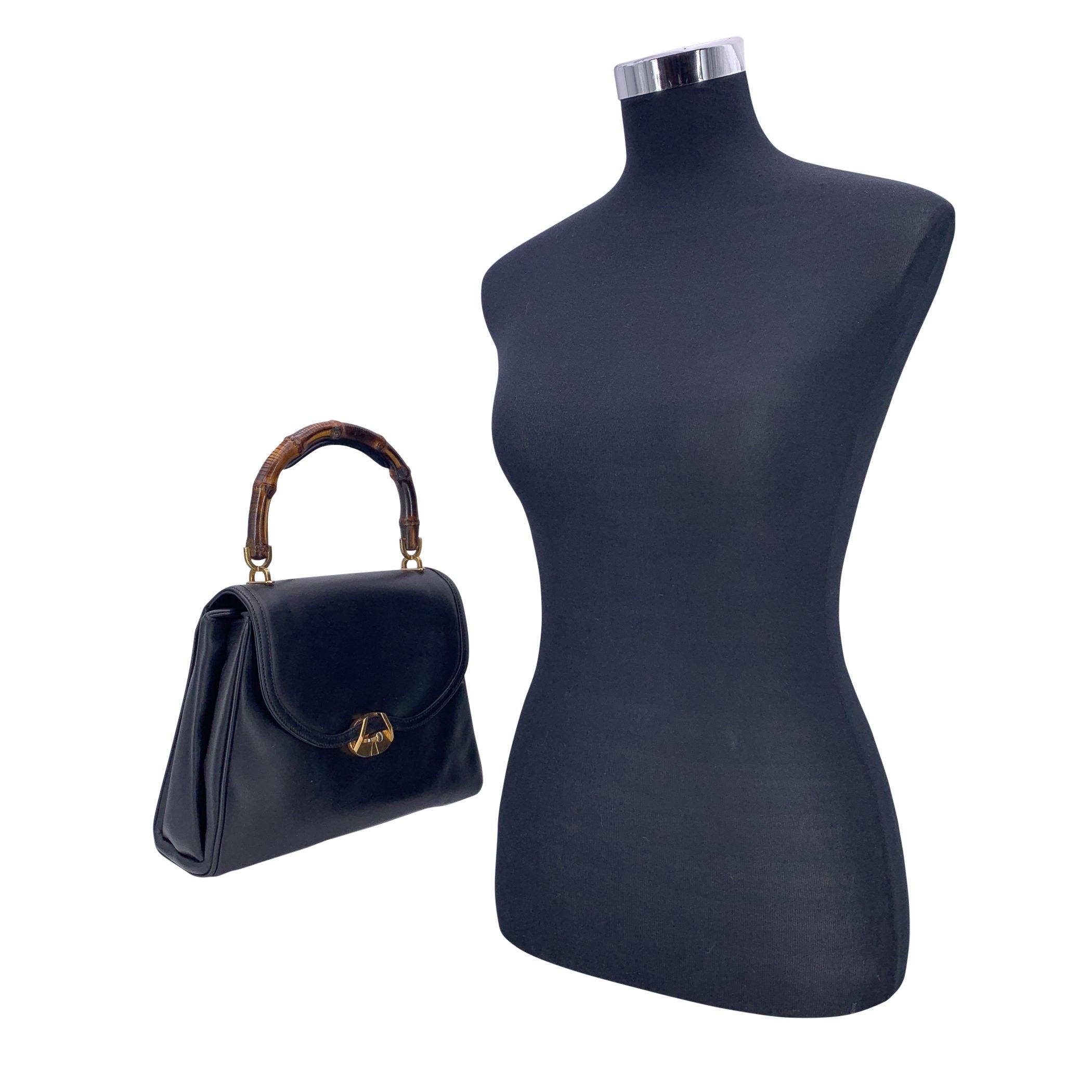 Pièce intemporelle issue du passé historique de Gucci, ce sac à main vintage en cuir noir reflète l'élégance caractéristique de la maison. Sa poignée sculpturale en bambou - un détail emblématique introduit pour la première fois par les artisans de