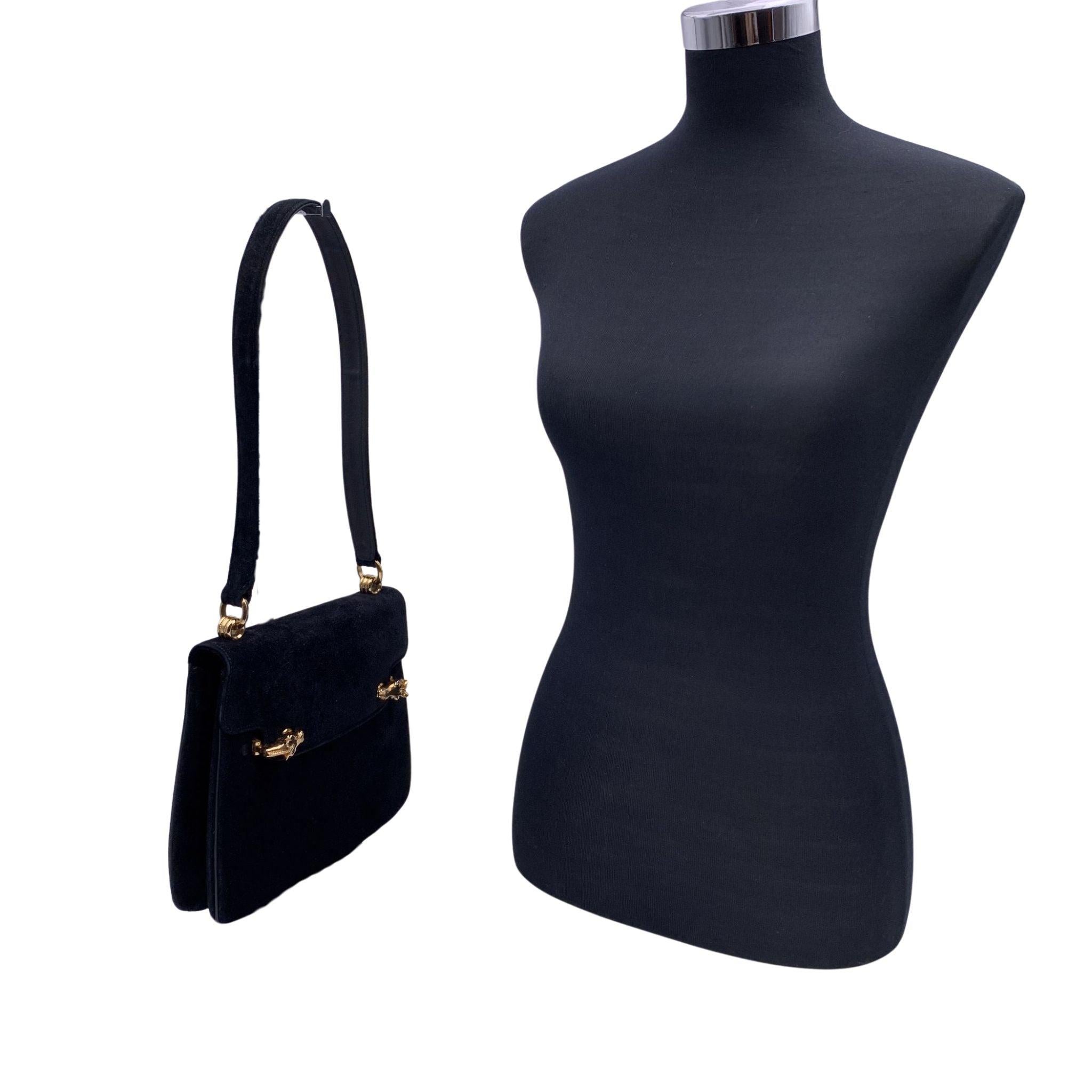 Vintage Gucci shoulder bag in black suede and leather from the 60s. Elizabeth Taylor owned the same style,and the bag was sold at auction in 2014 for $4,062.50. Flap closure with beautiful gold metal horse heads closure on the front. Black leather