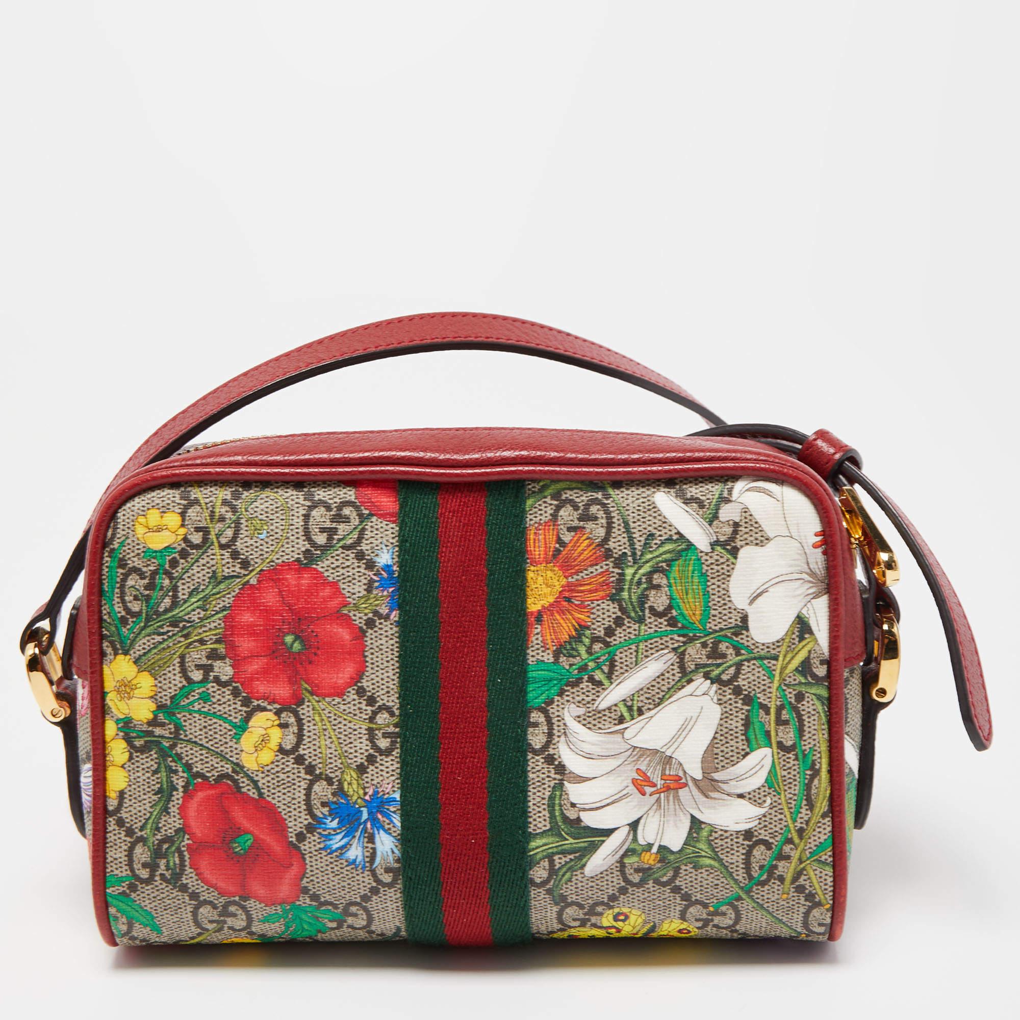 The Gucci Ophidia crossbody bag is a compact yet stylish accessory. It features the iconic GG Supreme monogram canvas with a floral pattern, a red leather trim, and a long strap for versatile wear. This bag effortlessly blends luxury and