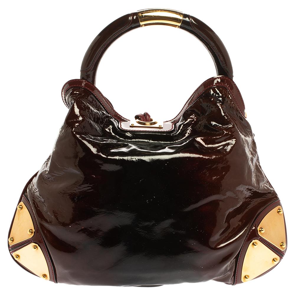 Crafted from patent leather, this Gucci number has a top with two bamboo-detailed tassels and a spacious fabric interior. It also features a sturdy top handle, armored corners, and gold-tone hardware. Flaunt this beauty wherever you go and you'll