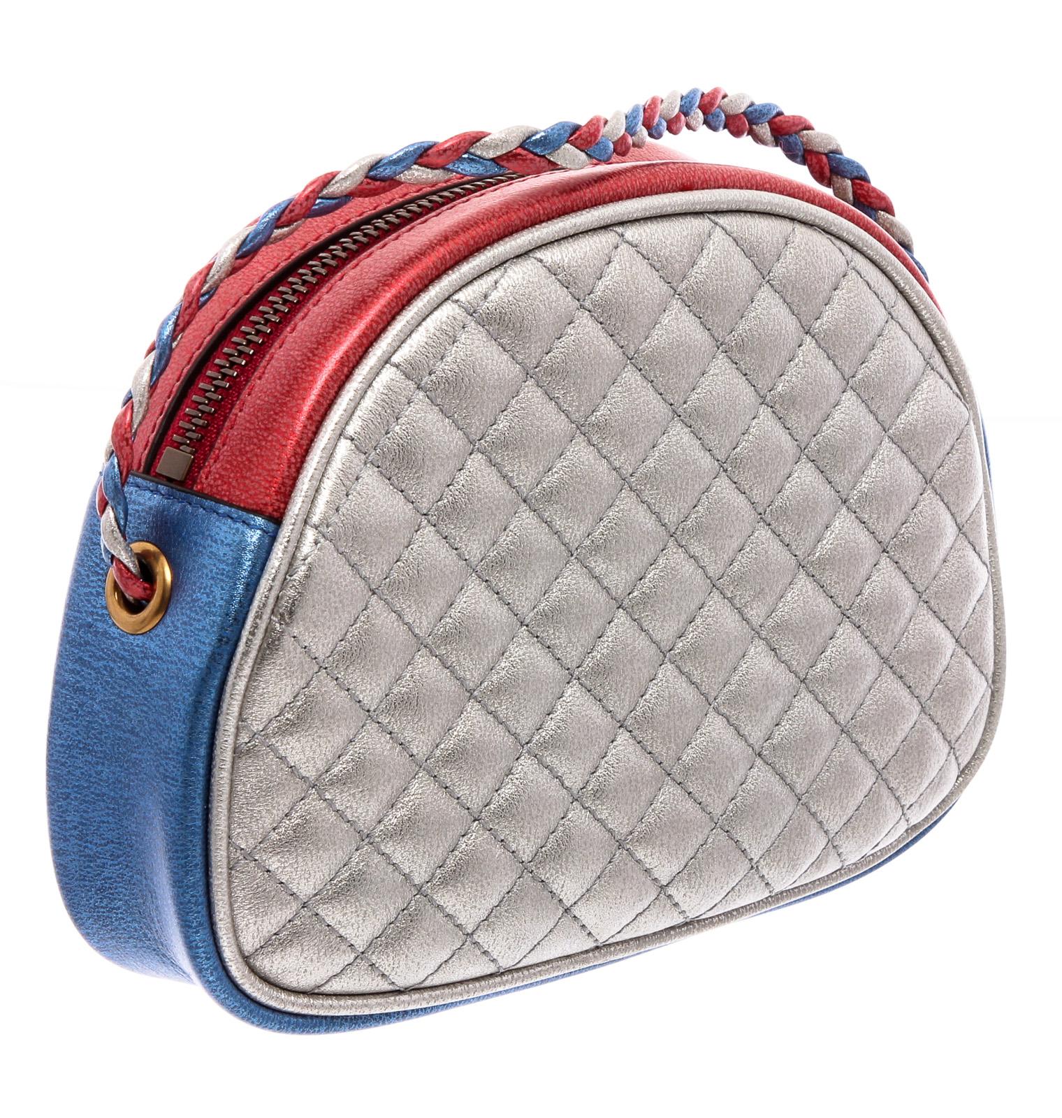 Gucci Mini Trapuntata crossbody bag crafted of textured calfskin leather in laminated red and blue with silver piping. The shoulder bag features a waist length braided shoulder strap and has combined its horse bit and interlocked G insignias in gold