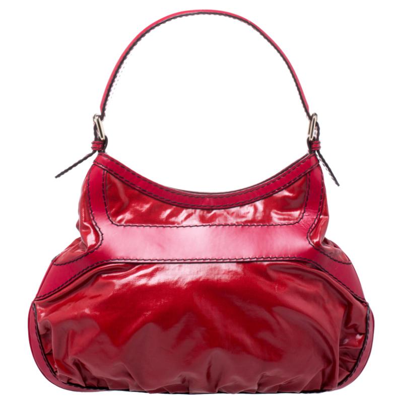 This stunning hobo bag by Gucci makes a statement. Crafted in Italy, it is made from lovely coated canvas and leather and comes in a striking shade of red. This Queen hobo is held by a single shoulder strap and features an oversized buckle in