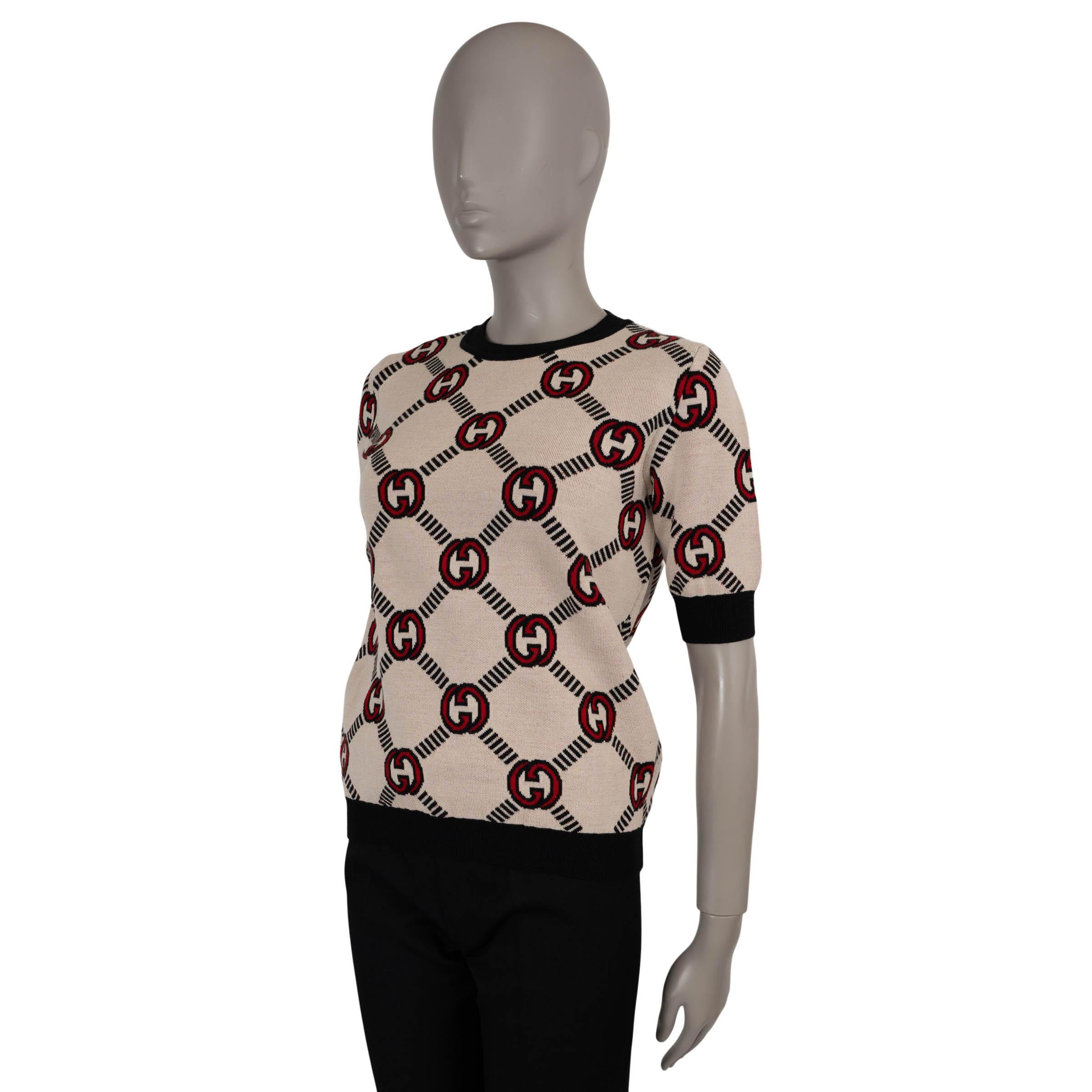This 100% authentic Gucci reversible sweater in GG jacquard knit wool (98%), elastane (1%), and polyamide (1%) offers two distinct looks in one. One side features a cream base with red and black details, while the reverse showcases a black base with