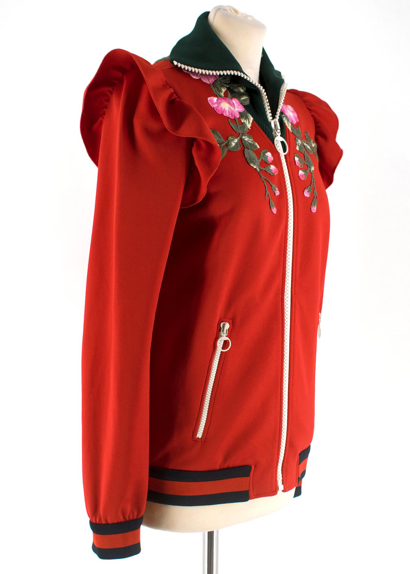 Gucci Red Embroidered Webstripe High Neck Tracksuit

High neck elastic collar
Embroidered rose detail on chest
Ruffled detail at shoulders
Elastic at wrist and waist
Thick, stretchy material
Striped detail on both pieces
Fitted trousers
Zippers at