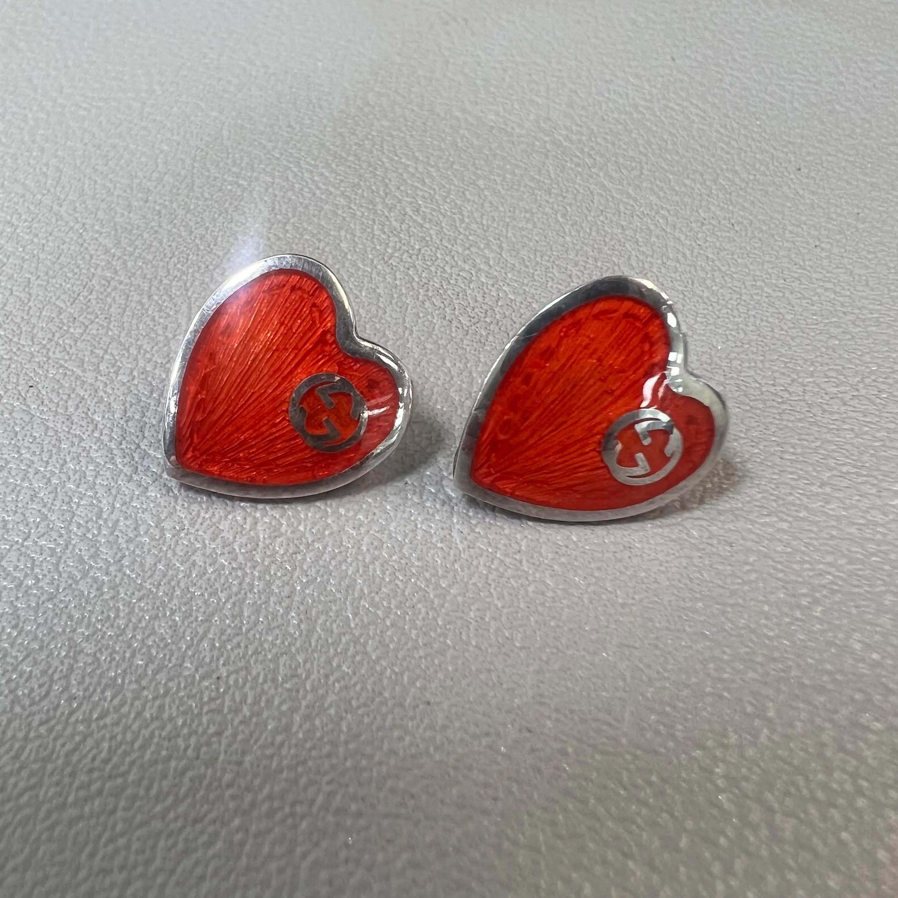 GUCCI red enamel interlocking G heart stud earrings. Crafted in 925 sterling silver. Earring size: 12mm x 13mm. Total weight: 3.10 grams. Push back closure. Comes with one Gucci stamped push back closure and one regular. Made in Italy. Excellent