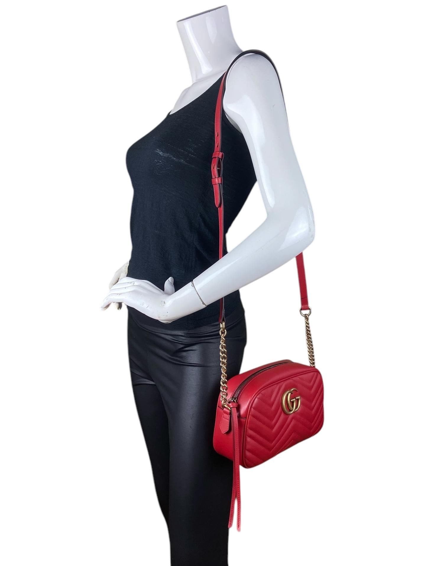 Sac à bandoulière Marmont en cuir matelassé rouge GG de Gucci. Le petit sac pour appareil photo GG Marmont a une forme doucement structurée et une fermeture à glissière sur le dessus avec le matériel Double G. La bandoulière en chaîne est agrémentée