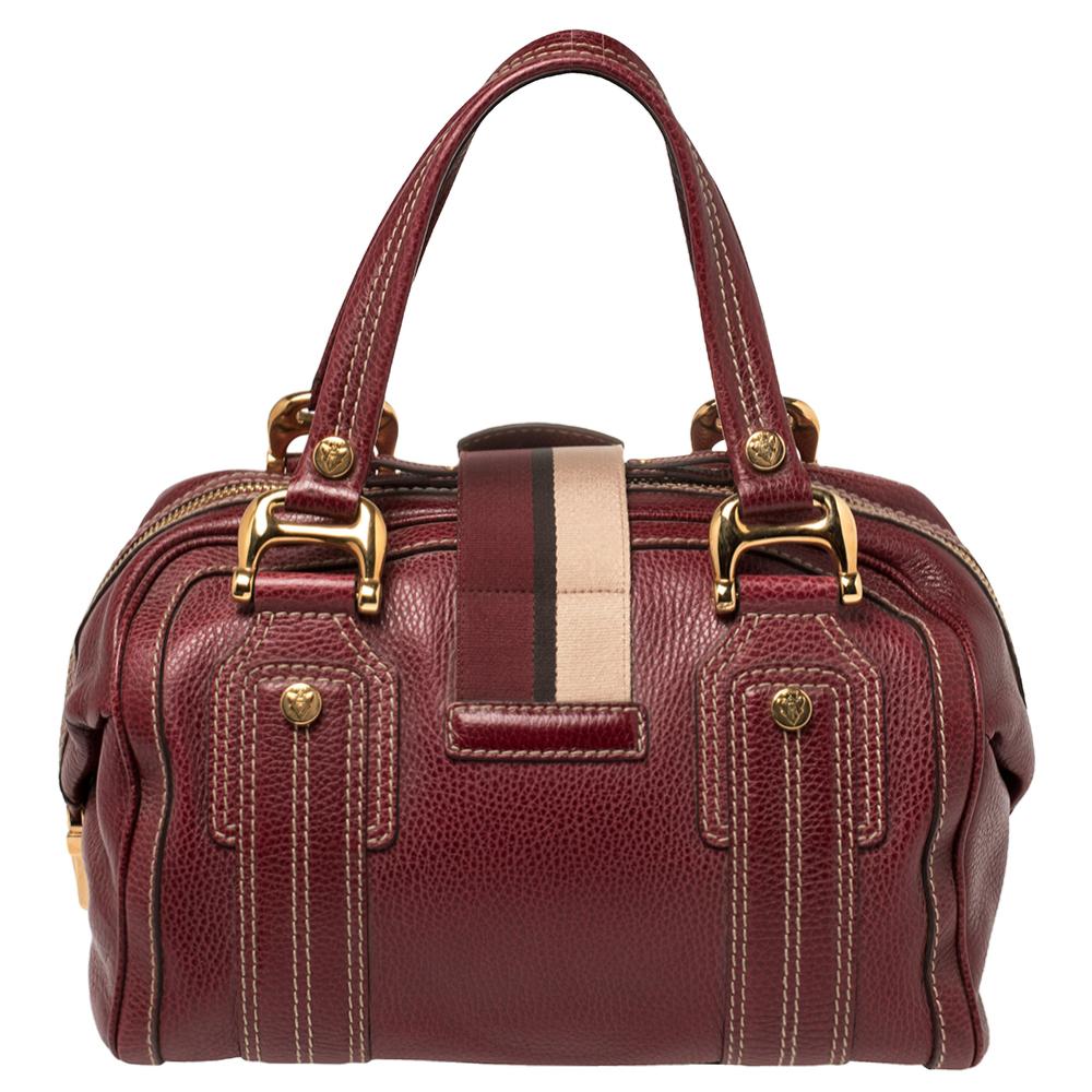 A truly posh and elegant piece to add to your collection. This Aviatrix Boston bag by Gucci is crafted from grained leather and styled with a flap that carries an emblem for a lock. It also has a top zip closure, two handles, protective metal feet,