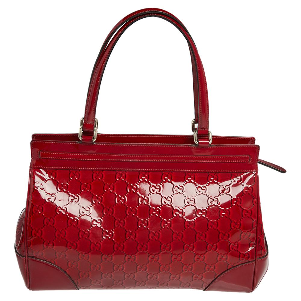 This stunning bag by Gucci is perfect for everyday use. Crafted from the signature Guccissima patent leather, it has a classic silhouette. The striking red bag has two handles, gold-tone hardware, a suede-lined interior and a bow on the front. With