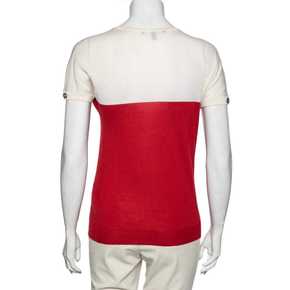 The usage of the red and ivory shades lends this Gucci jumper an attractive contrast. Made finely from cashmere, it is styled with button-detailed short sleeves and a round neckline. Pair it with black pants or denim to complete the ensemble.

