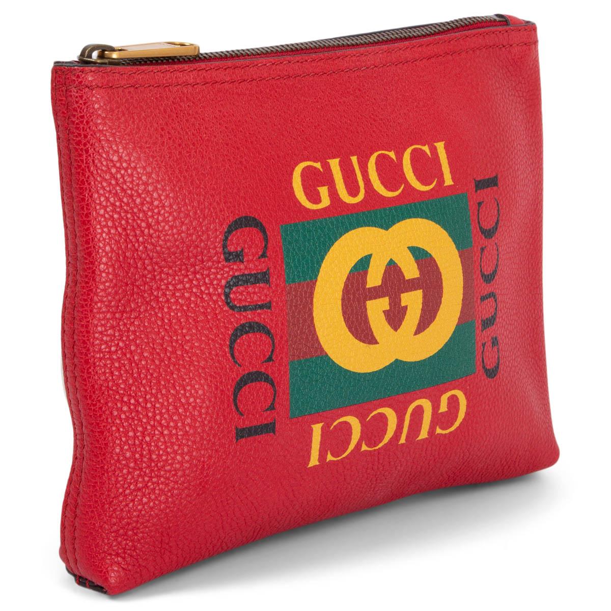 100% authentic Gucci pouch in red grained leather with classic green and yellow printed web stripes and logo. Opens with a zipper on top and is unlined. Has been carried once and is in virtually new condition. Comes with dust bag.