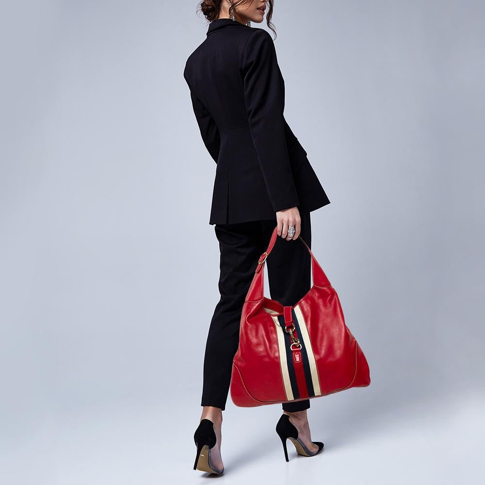 Gucci has always offered a bevy of cult-favorite bags, just like this Jackie O’ Bouvier hobo created as a homage to Jacqueline Kennedy Onassis. It is crafted from canvas and leather in a red shade and flaunts the Web stripe on the front. A piston