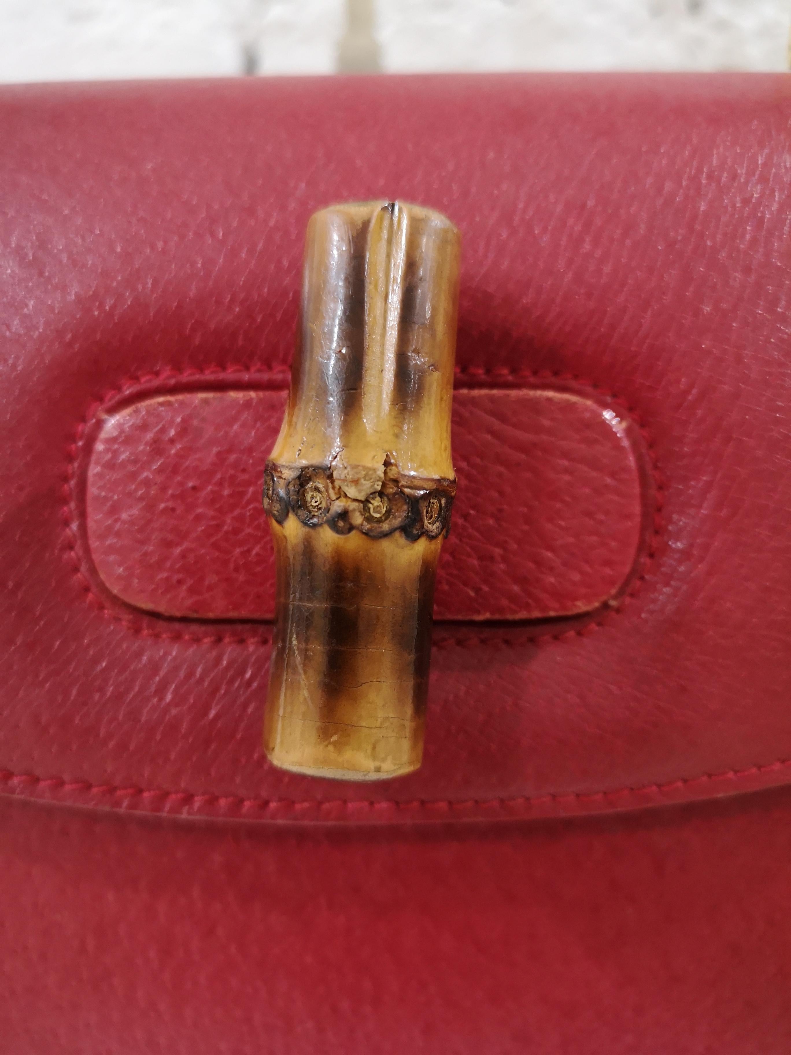 Red leather Bamboo Line handbag from Gucci Vintage featuring a foldover top, an internal zipped pocket, a curved silhouette and a brown bamboo top handle. 
Measurements are in CM  are 26  * 19 ( without handle,) 32 ( with handle) 9 depth 