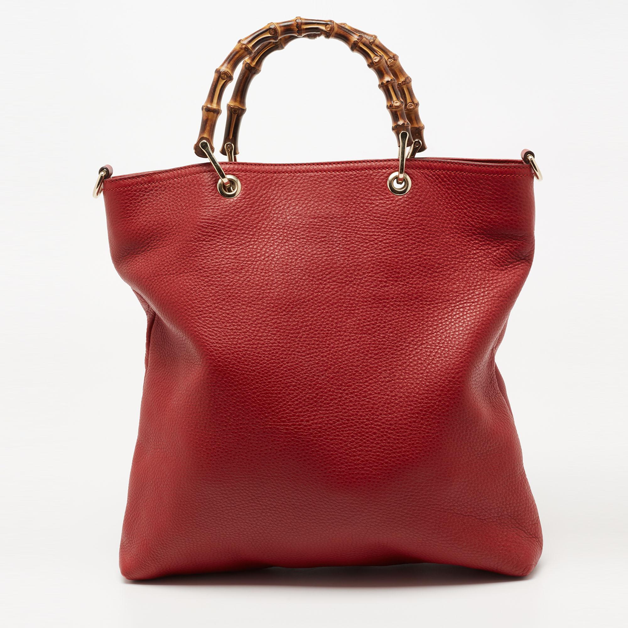 One of the most stunning creations from the House of Gucci is this tote. It is made from red leather on the exterior. It features a canvas-lined interior and gold-tone hardware. The structured silhouette of the tote is supported by dual Bamboo