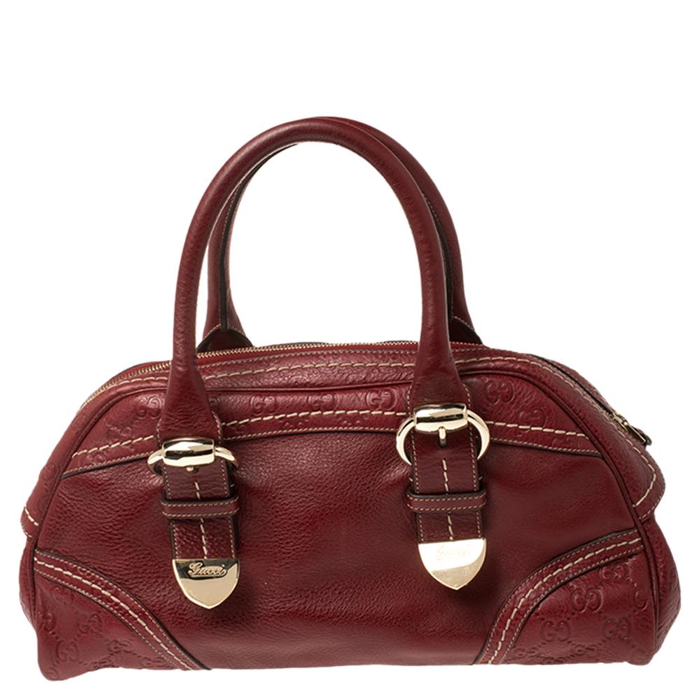 Luxuriously crafted, this Gucci bowler bag is splendid to look at and flaunt this season. It has been crafted from red leather and features dual top handles and gold-tone buckle details. The fabric lining of the bag defines its durability and