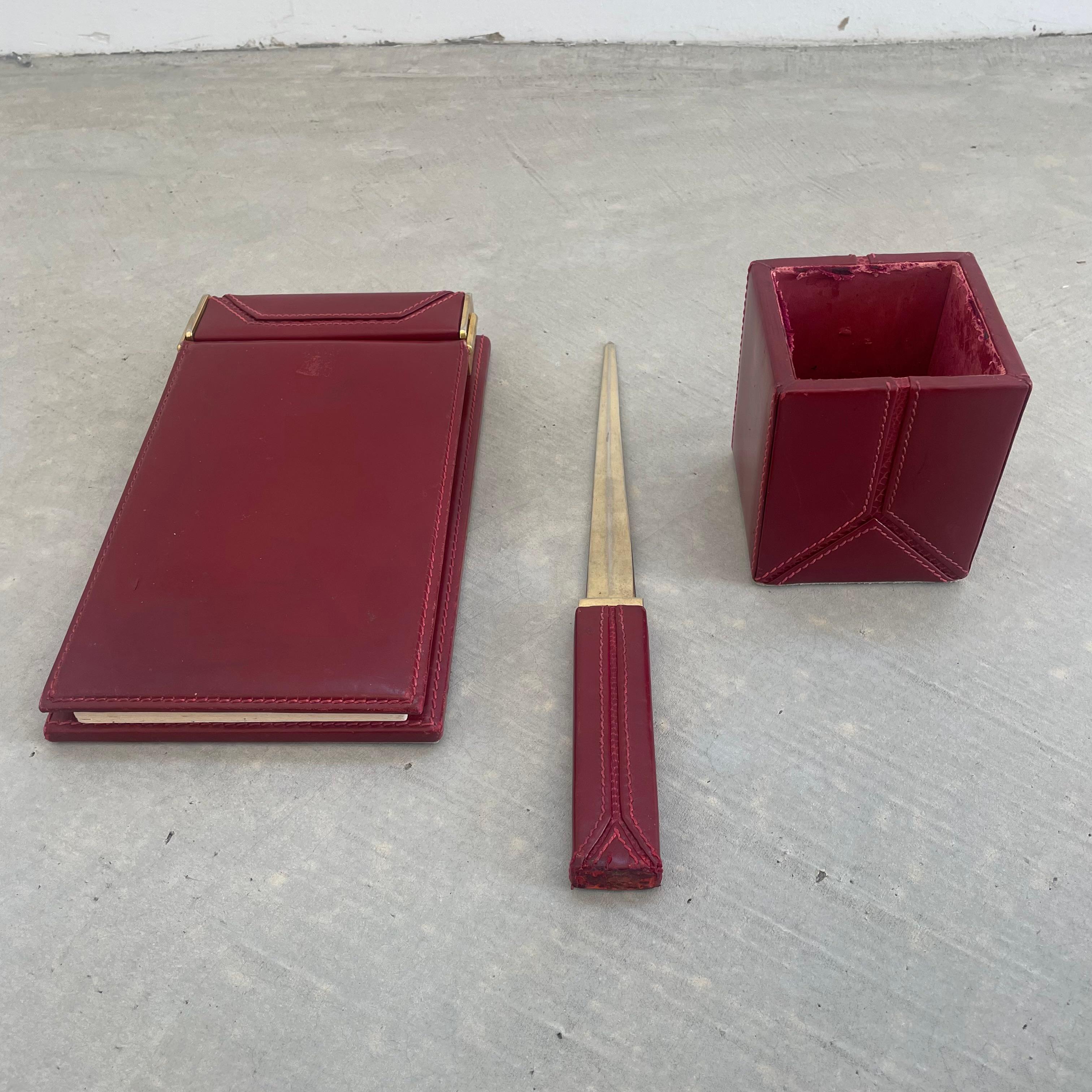 Hübsches Schreibtischset aus rotem Leder von Gucci. Hergestellt in Italien, ca. 1980er Jahre. Das Set besteht aus einem Notizblock mit Papier, einem Stifthalter und einem Brieföffner. Reiche Farbe zu Leder mit Eidechsenhaut kontrastiert mit dem