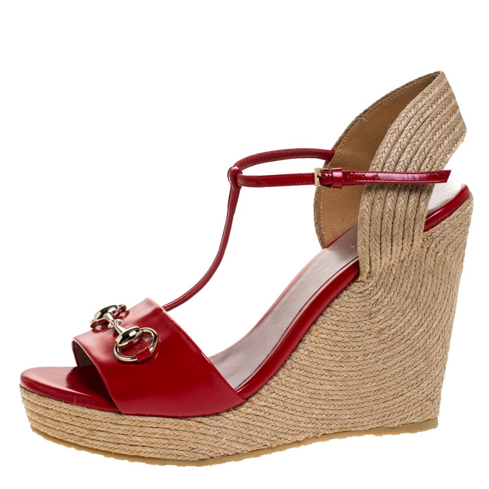 Gucci made these sandals to crown your feet with beauty. They are constructed with red leather straps at the front and ankles, a T-strap design and signature horsebit accents in gold-tone on the vamps. Espadrille wedge heels make the pair ready to