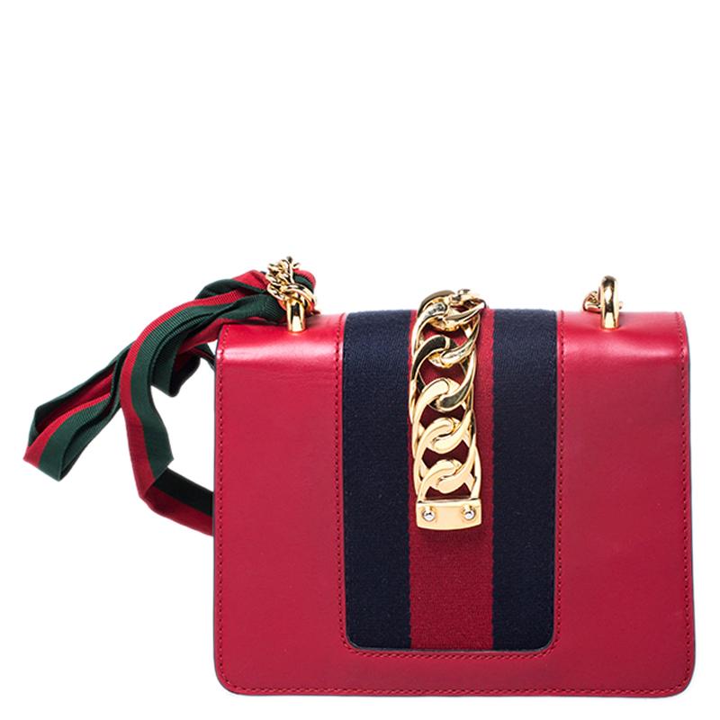 From the house of Gucci comes this gorgeous Sylvie shoulder bag that will perfectly complement all your outfits. It has been luxuriously crafted in Italy and is made from red leather and styled with a signature chain-web decorated flap, a buckle