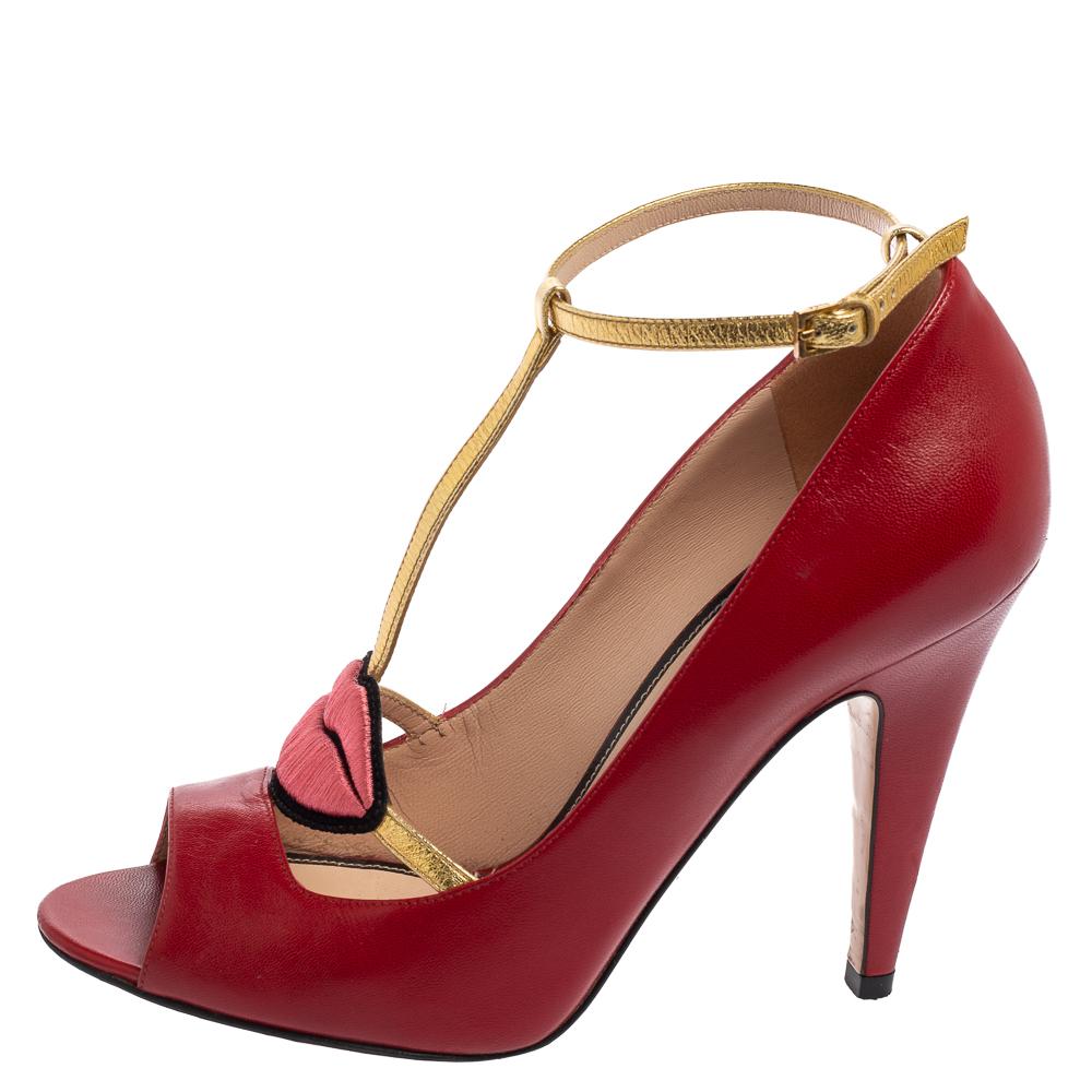 How can one not fall in love with these sandals by Gucci! They've been beautifully crafted from red-hued leather and styled with playful embroidered lips on the uppers. The sandals carry open toes, a T-strap in gold forming the ankle fastenings, and