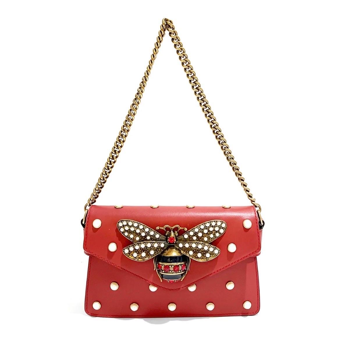Red Leather Pearl Studded Mini Broadway Bee Envelope Bag by Gucci  
Made in Italy
Red calfskin leather
Large decorative pearl studded bee in front of bag
Bee has red crystals and blue stripe body detail
Pearl studded embellishment throughout