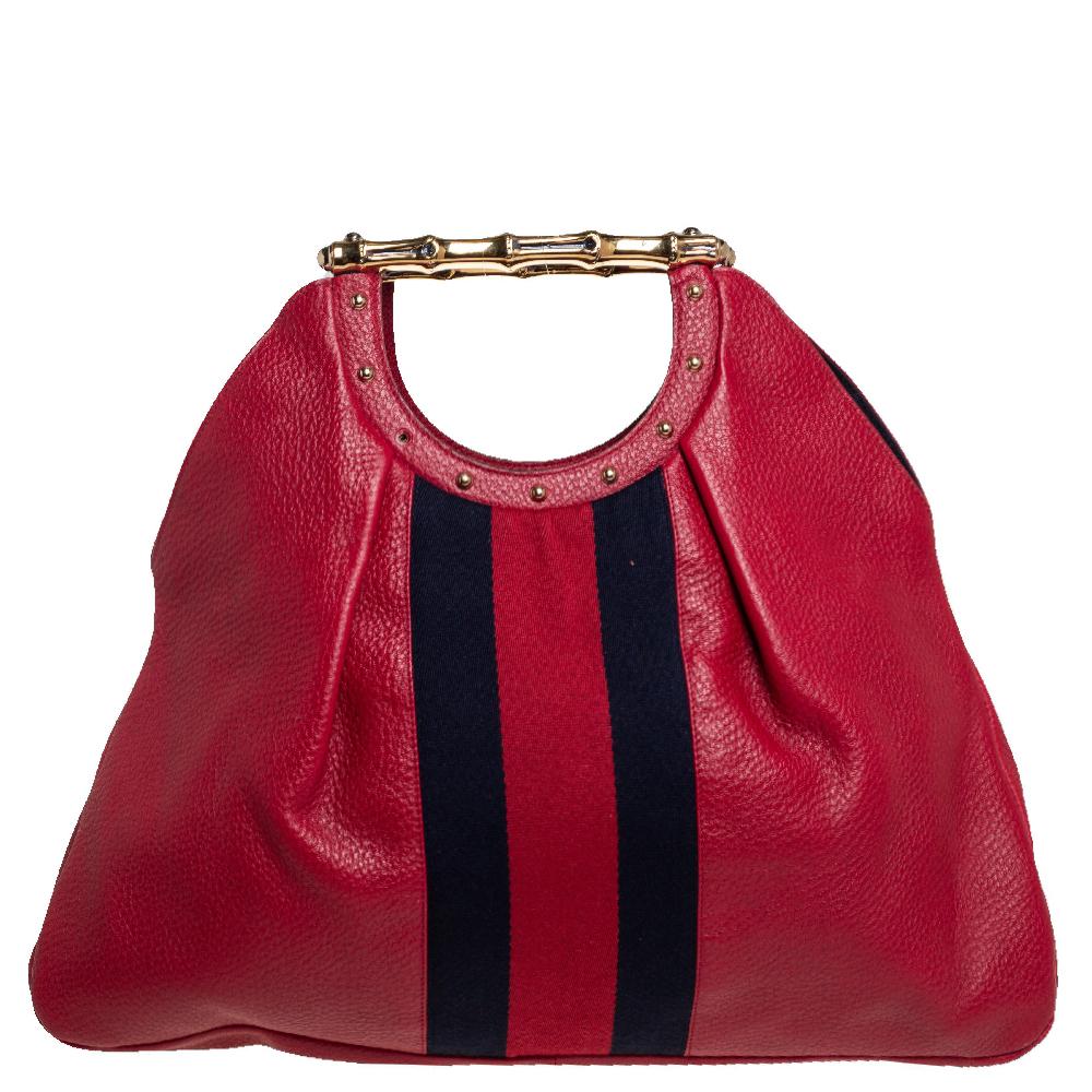 Gucci has always offered a bevy of cult-favorite bags, just like this tote created for everyday use. It is crafted from leather in a red hue and suspends from metal bamboo-like handles. The creation flaunts the signature Web stripes on the front and