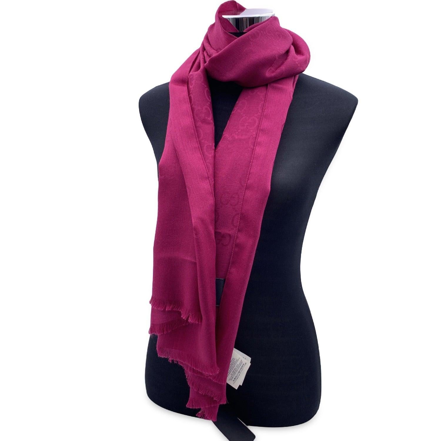 Red Magenta GG jacquard wool and silk scarf by Gucci. Width: 45 cm. Lenght: 180 cm. Frayed edges. Made in Italy. Composition: 70% wool 30% silk. Details MATERIAL: Wool COLOR: Red MODEL: n.a. GENDER: Unisex Adults COUNTRY OF MANUFACTURE: Italy