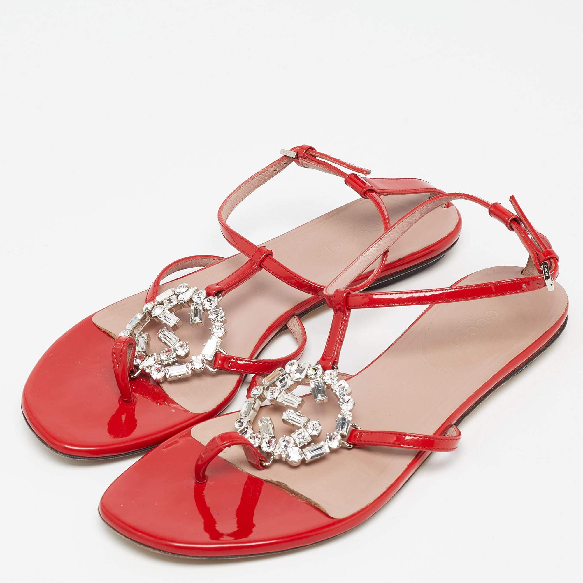 Coming from the house of Gucci are these uber-chic patent leather sandals that will make your feet dazzle. Crafted from red, the luxurious ankle-strap flats have beautiful, crystal-embellished GG interlockings on the vamps. Buckle closures and