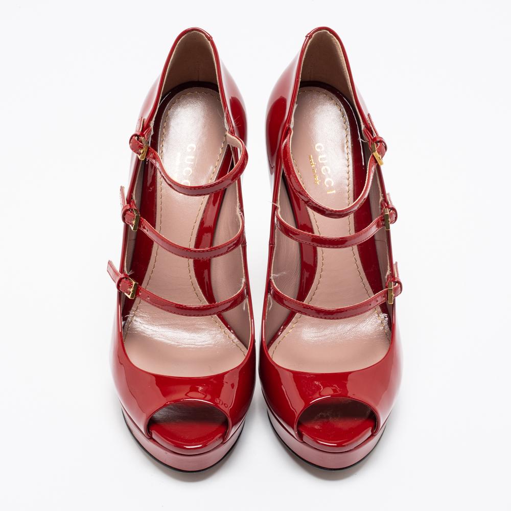 Finesse and glamorous poise will come naturally to you when you step out wearing this pair of red pumps from Gucci. Crafted from patent leather, the fabulous peep-toe pumps have been styled into a Mary-Jane design with buckled straps and 13 cm