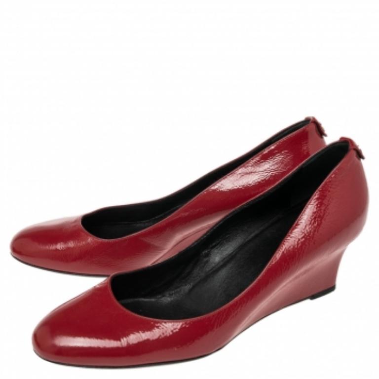 These red pumps from Gucci are simple but a must-have. Crafted using patent leather, and balanced on wedge heels, the round-toe pumps are complete with the logo on the counters. They are high in both style and comfort.