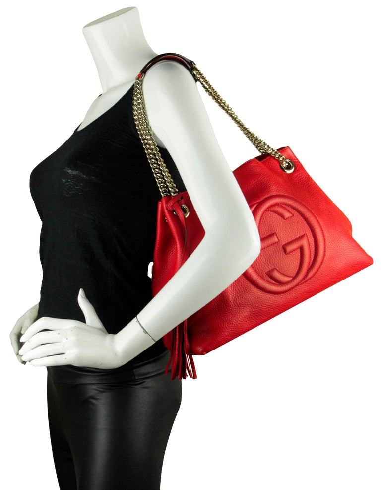 Gucci Red Pebbled Calfskin Leather Soho Chain Tote Bag. 

Made In: Italy
Color: Red
Hardware: Goldtone
Materials: Leather, metal
Lining: Beige textile
Closure/Opening: Open top with center hook
Exterior Pockets: None
Interior Pockets: Two open wall