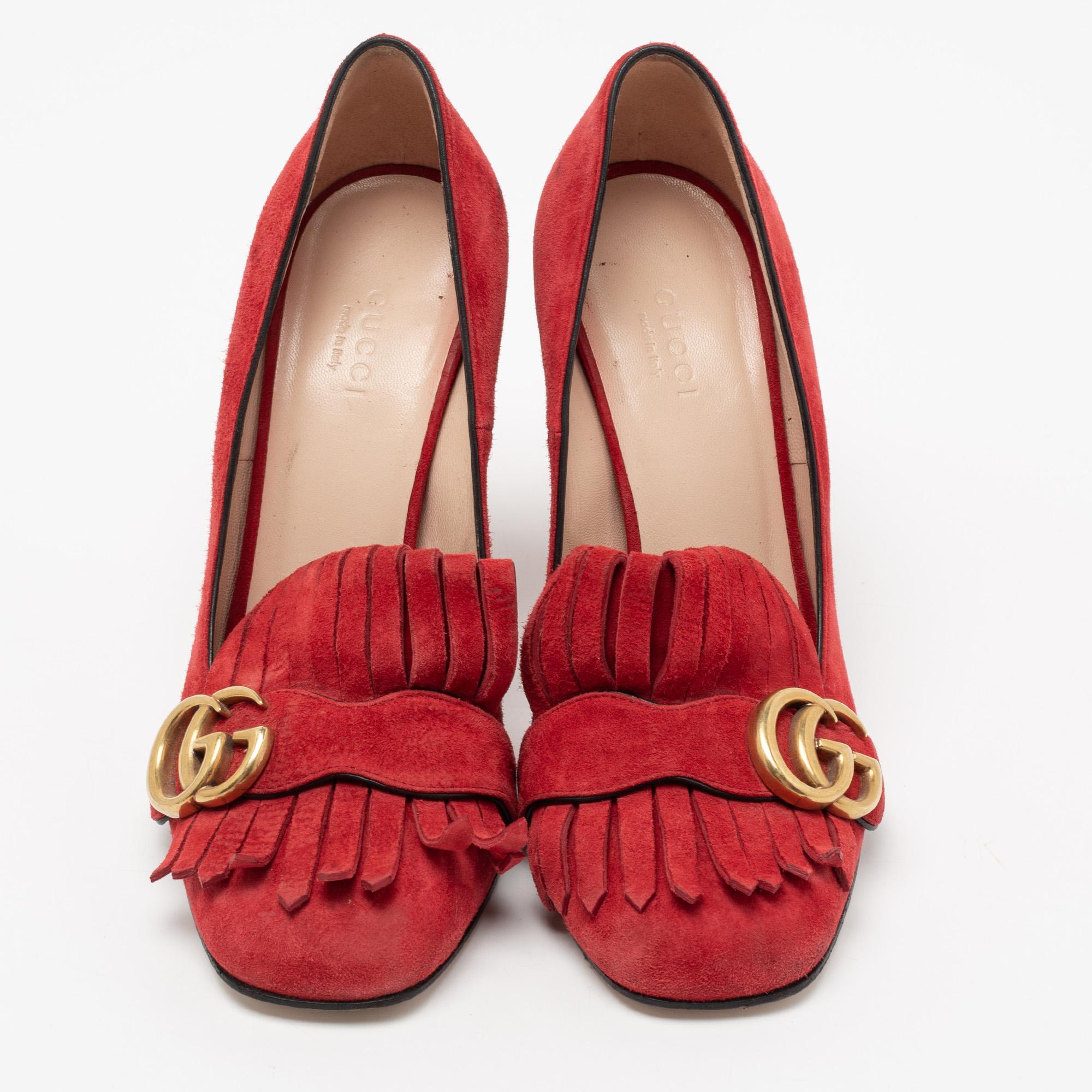 Glamourous and easy to style, this pair of GG Marmont pumps by Gucci is a stunner. They've been crafted from red suede and styled with folded fringes with the brand's signature GG on the uppers. Square toes and a set of block heels complete the