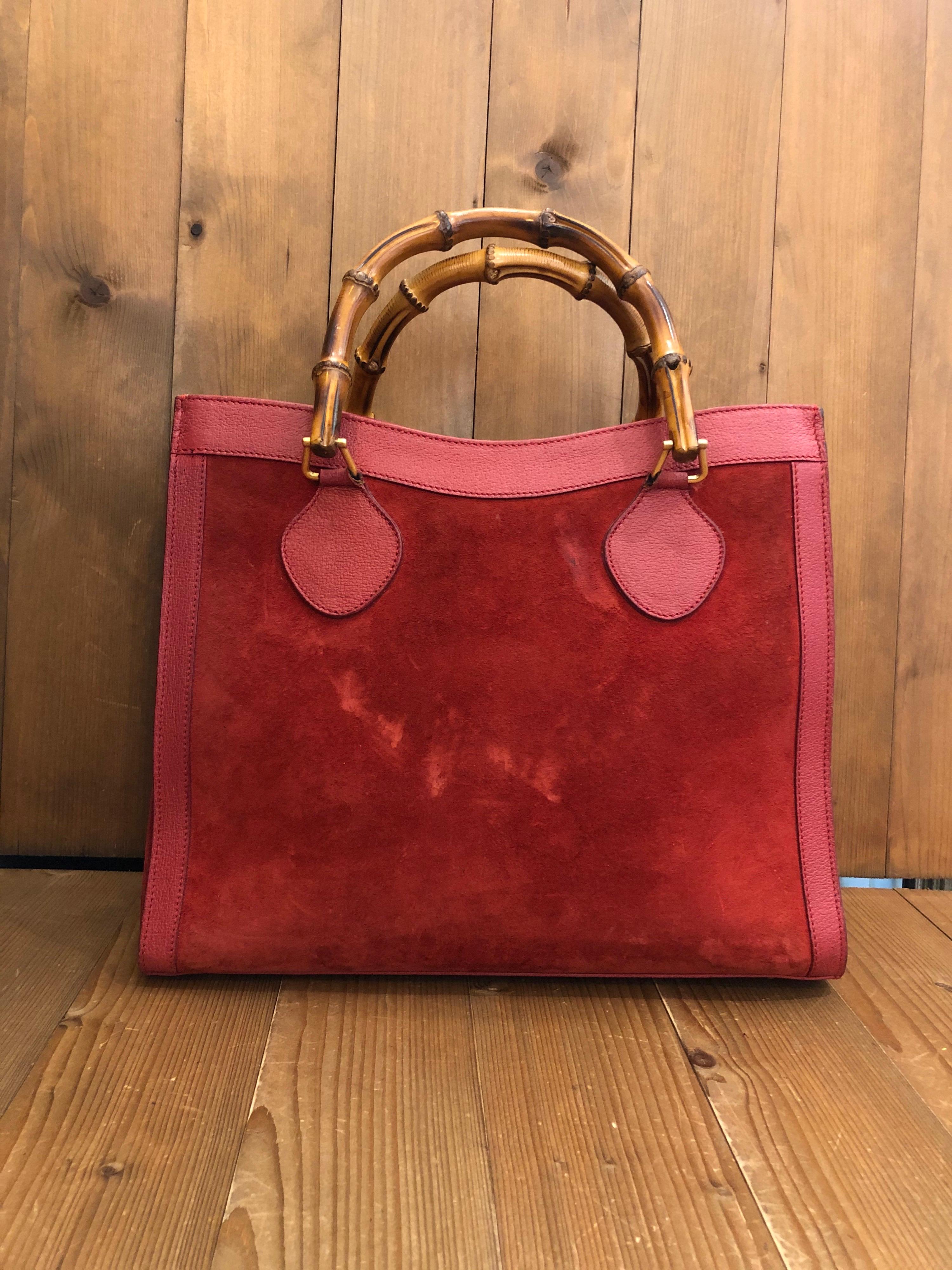 This vintage GUCCI Diana bamboo tote is crafted of pigskin’s leather and suede in burgundy and matt gold toned hardware. Top magnetic snap closure opens to a new interior in burgundy. It features two main compartments/one zip compartment and one