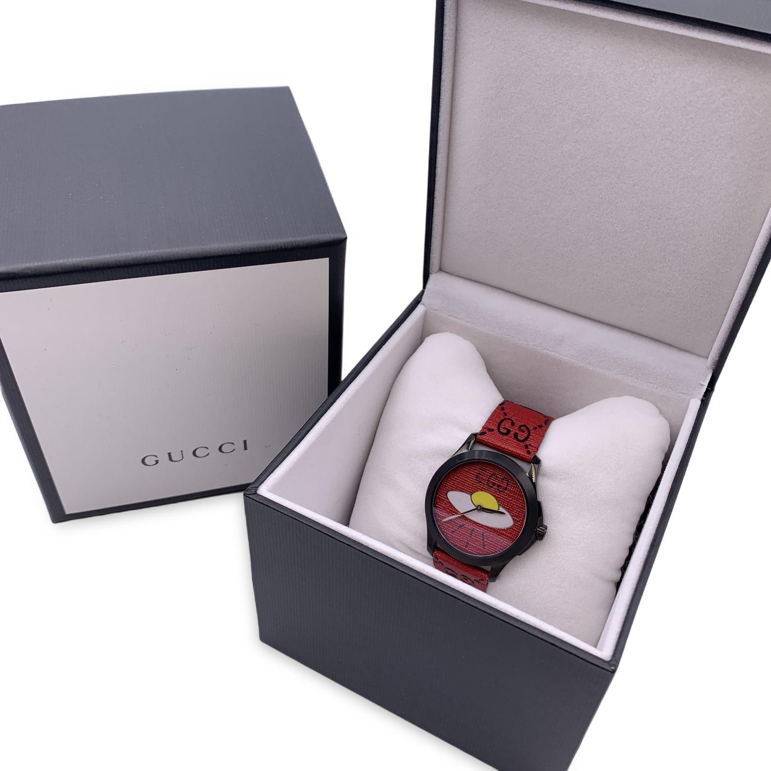 Gucci 'G-Timeless - Gucci Ghost Ufo Egg' stainless steel unisex watch. Model 126.4. Round black PVD Plated steel metal case (40 mm - crown included). Red dial with Ufo egg motif with two silver hands. Sapphire crystal. Swiss Made Quartz movement.